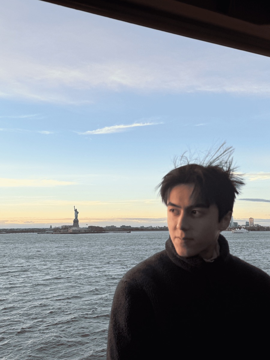 Akbar by the water with the Statue of Liberty in the background